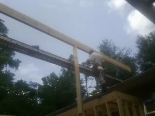 Carpenter setting a ridge beam over a new addition frame — Ice Dam Removal by Roofing Brothers in North Aurora
