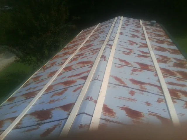 Rusted metal roof panels with new wood purlins before replacement — Storm Damage Roof Repair in North Aurora by Roofing Brothers
