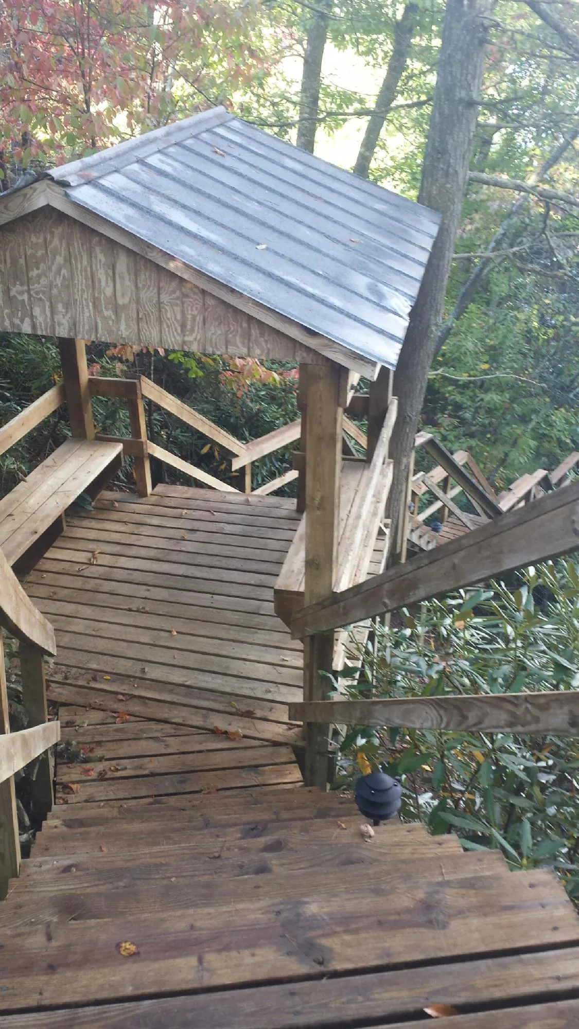 Metal roofed shelter over wooden steps on a wooded walkway — Skylight Repair & Installation work by our crew in North Aurora