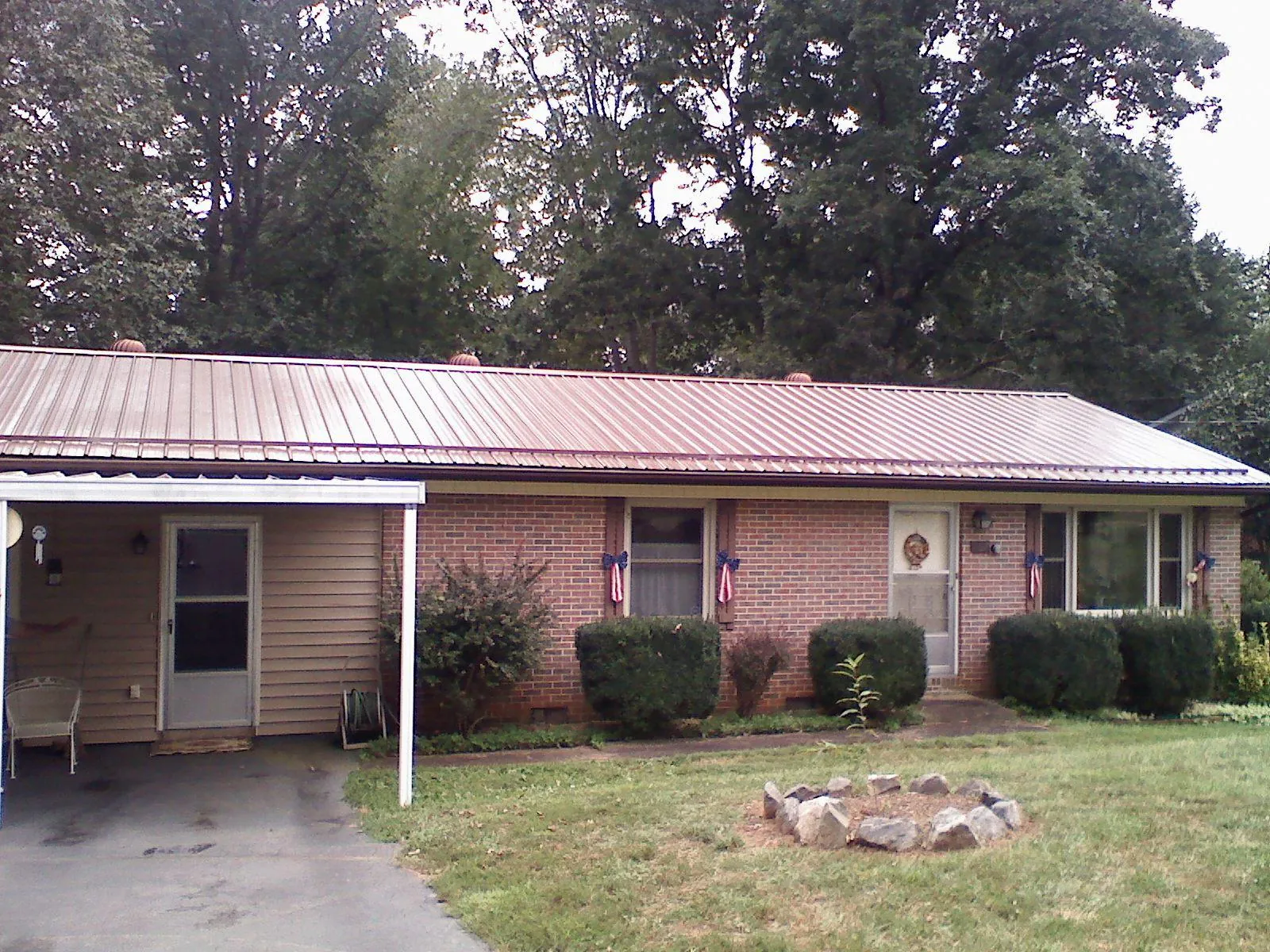 Bronze metal roof and carport on a brick ranch home — Roof Repair work by our crew in North Aurora